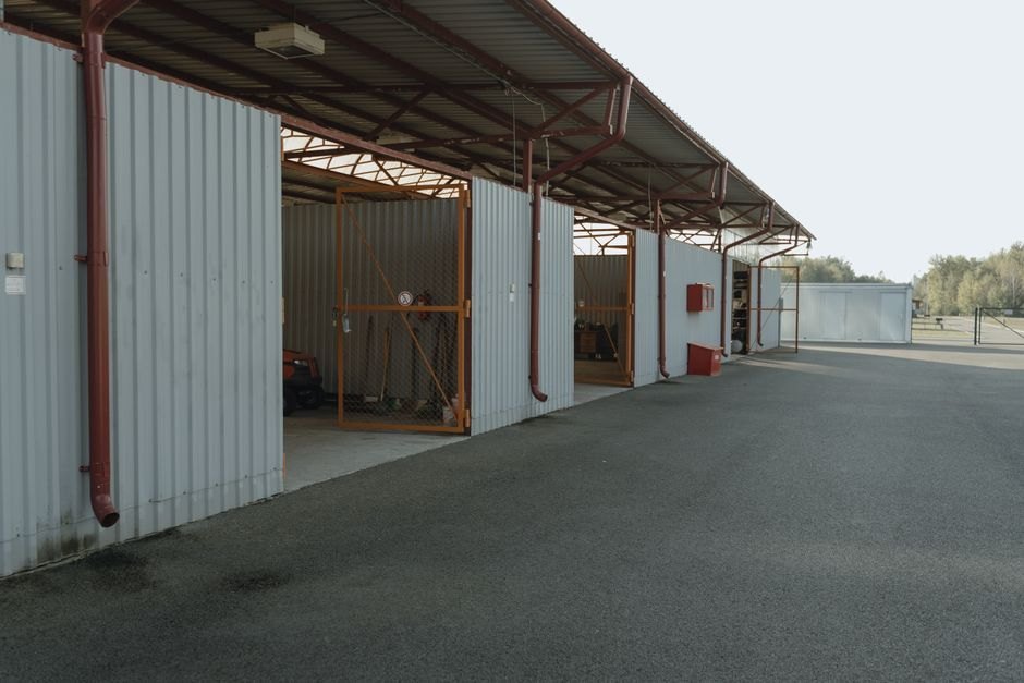 Un garage industriel vide avec des portes ouvertes et une vue sur un vaste espace extérieur