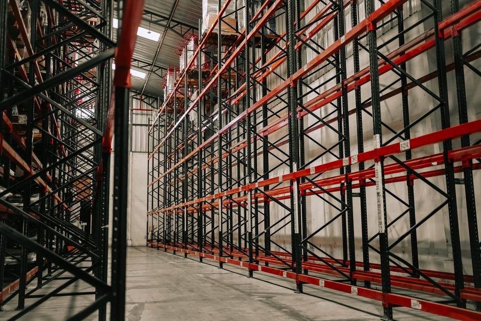 Intérieur spacieux d'un entrepôt avec des racks métalliques vides et un plafond haut