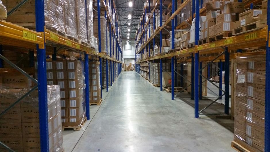 Vue intérieure d'un large couloir d'entrepôt bordé de piles de cartons organisées