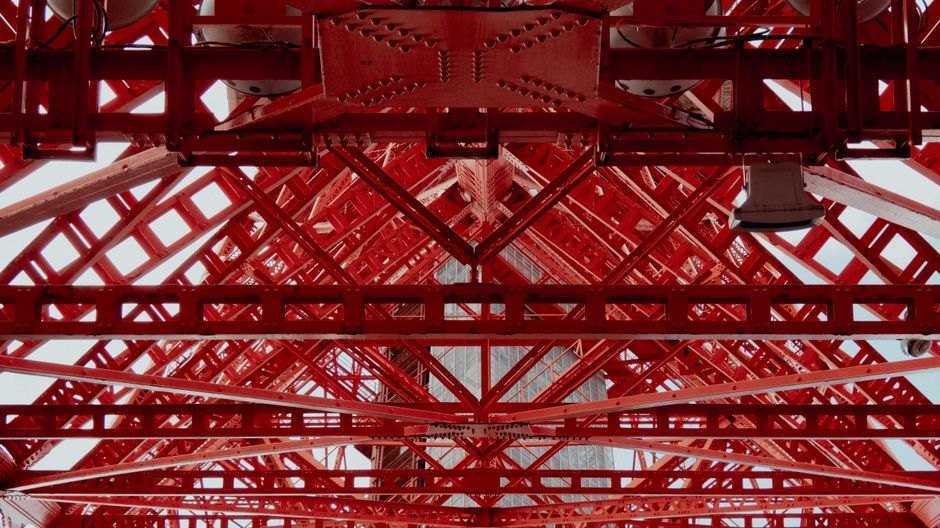 Vue détaillée d'une structure en acier rouge montrant des motifs géométriques et un design industriel